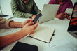© Prins Productions - Four workers gathered for discussion researching on smartphone and laptops brainstorming ideas.