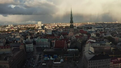 Fototapete - Rain shower over Riga, Latvia at sunset. Aerial view of the Riga old town at dusk with stormy clouds and light rain in the sunlight. Magical storm over city. Beautiful Latvia.