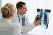 © Supachai - Doctor explaining  lung x-ray film of female patient at the hospital.