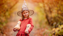 Little Girl Holding Pumpkins For Halloween