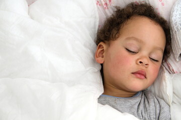 Canvas Print - baby sleeping wrapped up in blanket after having a good sleep in bed stock photo