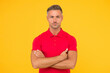 © be free - Handsome caucasian guy with unshaven face hair wear red thirt keeping arms crossed yellow background, confidence