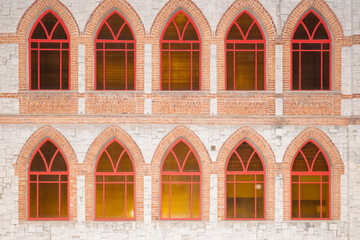 Wall Mural - stone wall with red Windows as background