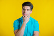 Thinking man looking up and around on yellow background. Pensive face expressions. Handsome male model.