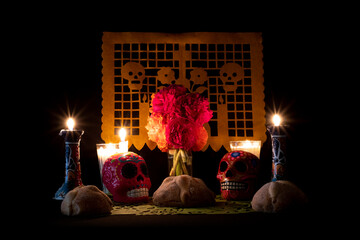 Day of the Dead offering from central Mexico with papel picado, veladoras, photography, flowers and bread of the dead