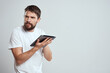 © SHOTPRIME STUDIO - emotional man with tablet in hand touch screen new technologies light background cropped view Copy Space