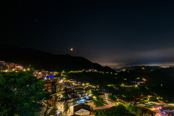 Poster - Jiufen village at night with mountain and ocrean view.