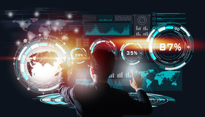 An energetic young businessman touching in front of a digital technology virtual screen .