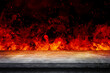 Side view of Empty concrete table top with orange fire or flame and sparkles in dark room.
