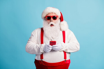 Sticker - Portrait of his he nice attractive amazed stunned white-haired Santa using device 5g app browsing media multimedia blogging shop order sale isolated bright vivid shine vibrant blue color background