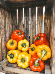 a fresh juicy peppers in an old wooden box