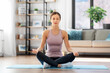 © Syda Productions - yoga, sport and healthy lifestyle concept - woman meditating in lotus pose at home