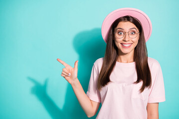 Wall Mural - Photo of surprised young girl point index finger empty space wear sunhat isolated over turquoise color background