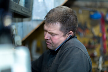 Wall Mural - Close-up portrait of a man in the workplace with a mobile phone