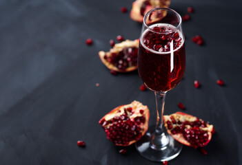 Wall Mural - christmas mimosa cocktail with champagne and pomegranate on a dark table
