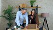 © viacheslav - Smiling woman and man employees working together in an office preparing presentation for meeting. Manager shows report to businessman on laptop computer