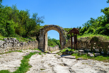 Wall Mural - Inner gates inside ancient city-fortress Chufut Kale, Bakhchisaray, Crimea. Bricks on both side of street are remains of middle fortification walls