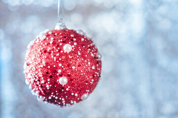 Christmas or new year card. Red Christmas ball on a blue bokeh background.