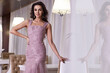 © indiraswork - Beautiful sexy young brunette woman with long wavy hair thin slender figure perfect body and pretty face make-up wearing a purple evening skinny dress and jewelry.