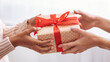 © Prostock-studio - Female hands holding and giving present box to woman