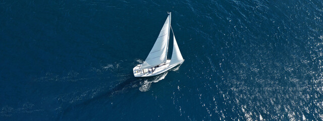 Wall Mural - Aerial drone ultra wide photo of beautiful sailboat cruising deep blue open ocean Mediterranean sea