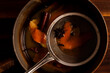 © Liz Clayman - Strainer in a sauce pan of mulled apple cider and orange cocktail.