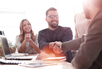 Fototapete - background image of the handshake of business partners in the office