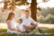 © Andriy Medvediuk - father, mother and son blow soap bubbles in the park together on a sunny summer day. happy family having fun outdoor