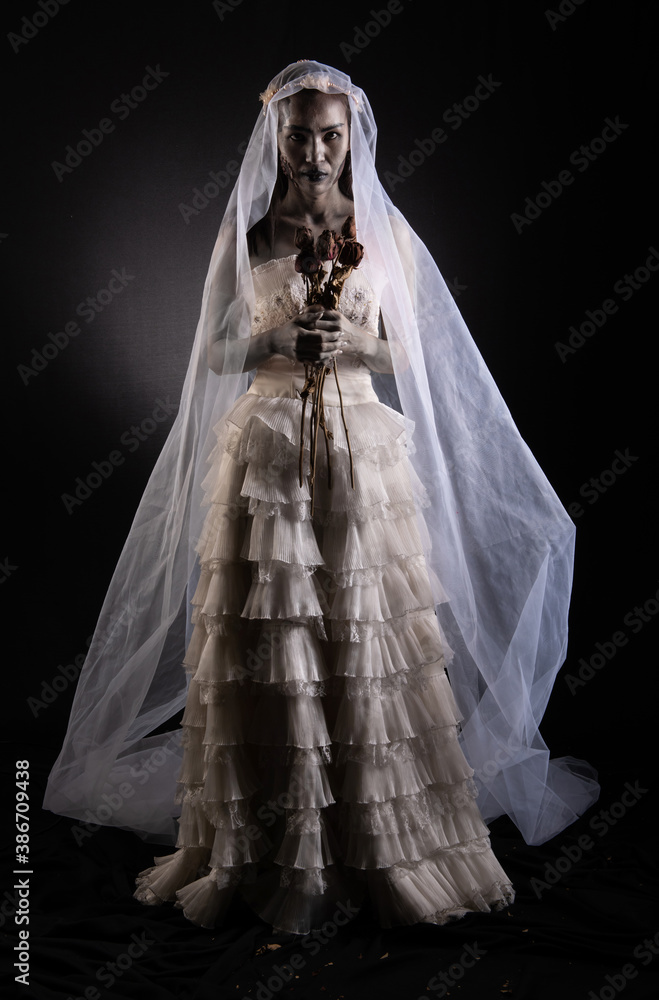 Horror Scene of a Possessed bride Woman in white dress black long hair ghost  zombie holding dried Rose Bouquet on hand in dark room isolated. halloween  scary concept Stock Photo | Adobe