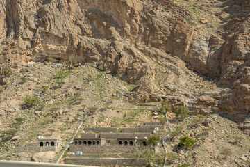 Arabic style stone houses carved into the slopes of Jebel Jais mountain of the North-Western Hajar range near the city of Ras Al Khaimah, United Arab Emirates.