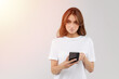 © Iryna - Attractive young woman using smart phone isolated on studio white background