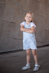 Little girl in an urban setting smiles at the camera.