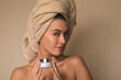 © Gener Vázquez - Joven Mujer mexicana con toalla en la cabeza mostrando crema facial humectante producto de belleza