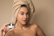 © Gener Vázquez - Joven Mujer mexicana con toalla en la cabeza mostrando crema facial humectante producto de belleza