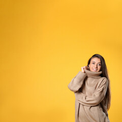 Sticker - Young woman in stylish brown sweater on yellow background, space for text