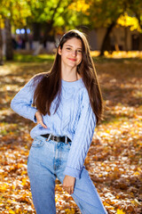 Wall Mural - Portrait of a young girl in blue sweater, autumn park outdoor