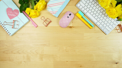 Wall Mural - Modern feminine pink, blue and yellow theme desktop workspace with yellow roses on stylish pale wood background. Top view blog hero header creative composition flat lay. Negative copy space.