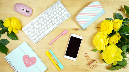 Wall Mural - Modern feminine pink, blue and yellow theme desktop workspace with yellow roses on stylish pale wood background. Top view blog hero header creative composition flat lay.