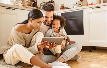 Canvas Print - happy multi ethnic family: parents and son using tablet  at home