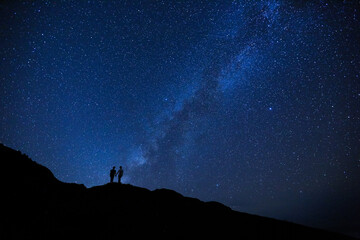silhouette of two girls / women on the hill. stargazing at oahu island, hawaii. starry night sky, mi
