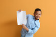 © Pixel-Shot - Little African-American boy with blank paper sheet on color background