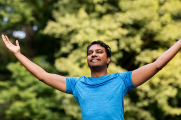 Wall Mural - fitness, sport and healthy lifestyle concept - happy indian man doing yoga at summer park