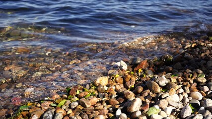 Wall Mural - Natural background with clear water and rocks on the shore