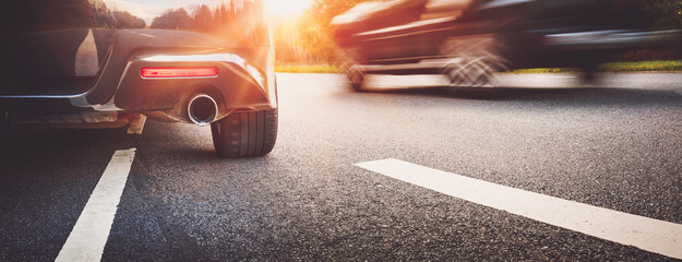 Car on asphalt road on summer day at park