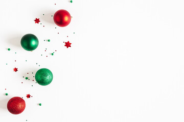 Christmas composition. Red and green decorations on white background. Christmas, winter, new year concept. Flat lay, top view, copy space