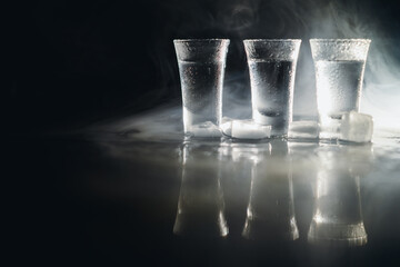 Wall Mural - Vodka in shot glasses on dark background.