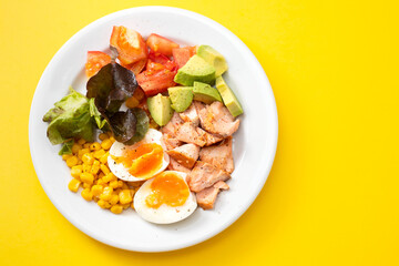 Sticker - salad salmon with vegetables and boiled egg on white plate on yellow background