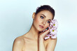 Portrait of a beautiful natural blue-eyed girl with lilac flowers in the wild. Nude make-up.