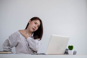 Concept Office Syndrome, Young Asian female office worker is tired from hard work, shoulder pain due to working hours consecutively.