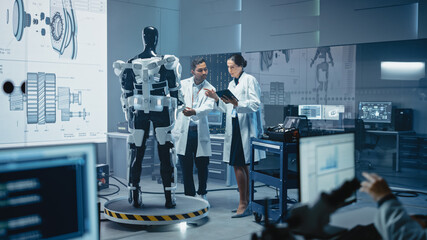 Wall Mural - In Robotics Development Laboratory: Chief Female Engineer and Top Male Scientist Work on a Bionics Exoskeleton Prototype. Designing Powered Exosuit to Help Disabled People, Hard Labor Workers